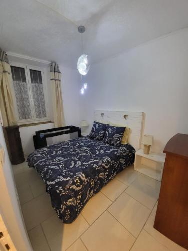 um quarto com uma cama com um edredão azul em Appart spacieux à 2 pas du port em La Ciotat