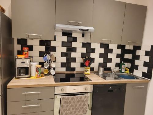 uma cozinha com uma parede xadrez em preto e branco em Appart spacieux à 2 pas du port em La Ciotat