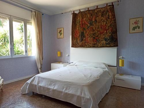 1 dormitorio con 1 cama y tapiz en la pared en Casa L'Escala, 4 dormitorios, 8 personas - ES-89-127, en Torroella de Montgrí