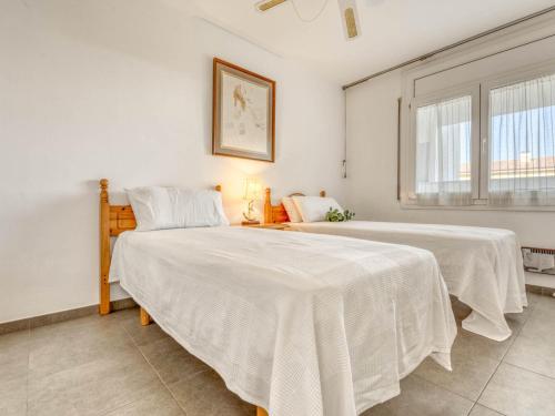 1 dormitorio con 2 camas y ventana en Apartamento L'Escala, 2 dormitorios, 6 personas - ES-89-125 en Torroella de Montgrí
