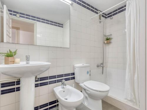 Baño blanco con aseo y lavamanos en Apartamento L'Escala, 2 dormitorios, 6 personas - ES-89-125 en Torroella de Montgrí