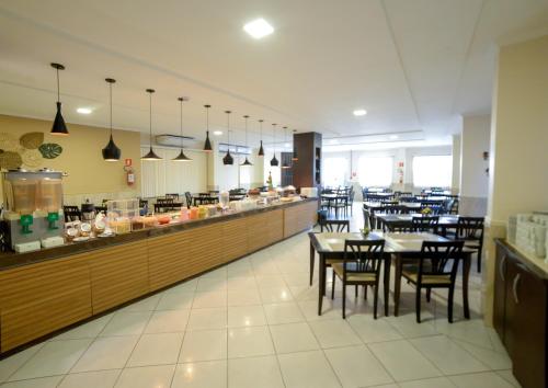 un restaurant avec des tables et des chaises et un buffet dans l'établissement Sandrin Praia Hotel, à Aracaju