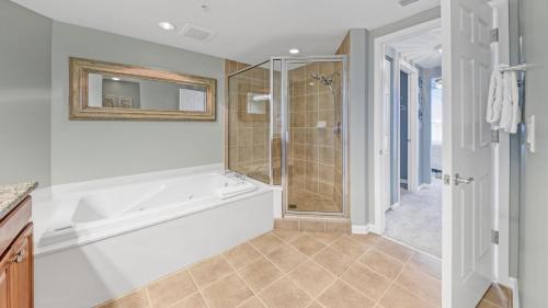 La salle de bains est pourvue d'une douche et d'une baignoire blanche. dans l'établissement St Lucia 1204 a Luxury Condo with Gulf Views, à Destin