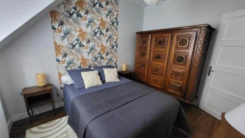 une chambre avec un lit et une armoire en bois dans l'établissement Maison de ville avec garage, à Beaugency