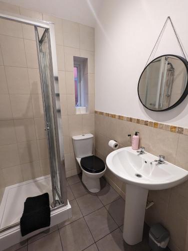 a bathroom with a sink and a toilet and a mirror at Cosy 1 Bedroom Apartment in the Heart of Llandudno in Llandudno
