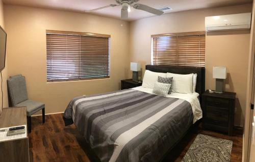 a bedroom with a bed and a chair and windows at Mountain View Apartment, Residential Area, Private Entrance in Sedona