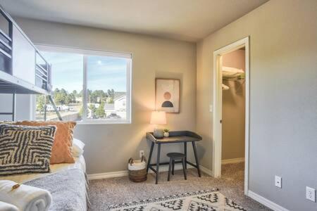 a bedroom with a bed and a table and a window at _Entire Home_Game Room_Basement_FirePit_ in Palmer Lake