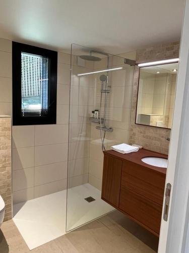 une salle de bain avec une douche, un lavabo et un miroir dans l'établissement la Villa des Cap - à 400m Océan et Bassin, à Cap-Ferret