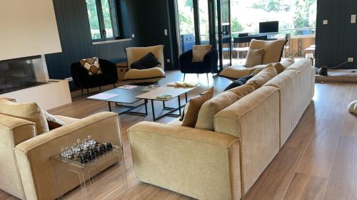 a living room with couches and chairs and a fireplace at la Villa des Cap - à 400m Océan et Bassin in Cap-Ferret