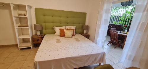 a bedroom with a large bed with a green headboard at Le Madina in Pamandzi