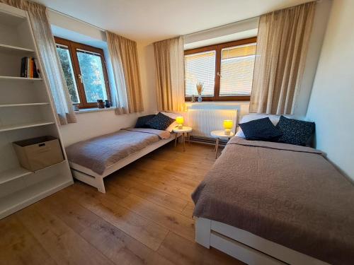 a bedroom with two beds and a couch in it at Domek na vinohradech in Hlohovec