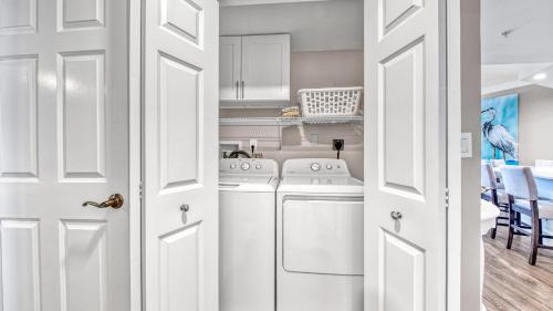 a kitchen with white appliances and a dining room at St Maarten 907 a Newly Renovated Luxury Beach Front 3 Bedroom 9th Floor Private Elevator in Destin
