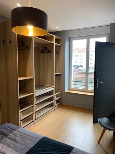 une chambre avec un lit et une grande fenêtre dans l'établissement Appartement Lumineux Hypercentre, à Épinal
