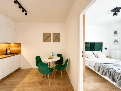 a bedroom with a bed and a table and chairs at Wygodne Mieszkania Nova Mikołowska 123 in Katowice