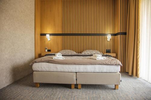 a bedroom with a bed with two towels on it at Lohovo Villa Bukva in Otoka