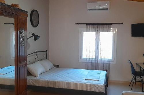 1 dormitorio con cama y ventana en Studio Rodies in Neohori Zacharo, 
