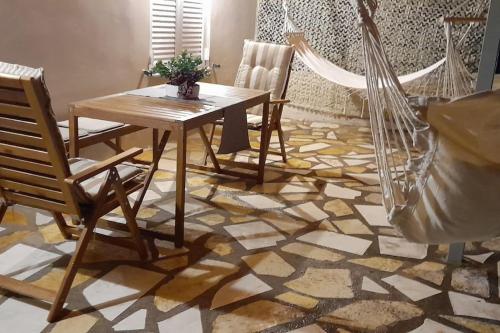 comedor con mesa y sillas en un suelo de mosaico en Studio Rodies in Neohori Zacharo, 
