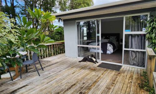 a dog laying on the deck of a house at Woodbury Farm in Takanini