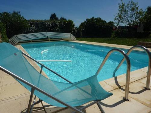 a blue chair sitting next to a swimming pool at Le Cercotin in Moroges