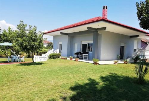 a small house with a lawn in front of it at Deppy's House κοντά στα λουτρά Πόζαρ in Chrysí