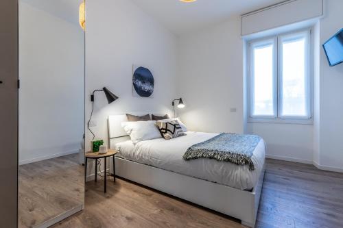 a white bedroom with a bed and a window at StayEasy Quadronno33 - 3 bedrooms, 2 baths - Duomo walking distance in Milan