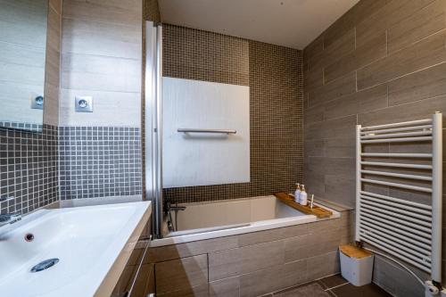 une salle de bain avec une baignoire et un lavabo dans l'établissement Le Bord de Seine 5min à pieds Gare Parking Privé Gratuit, à Rueil-Malmaison