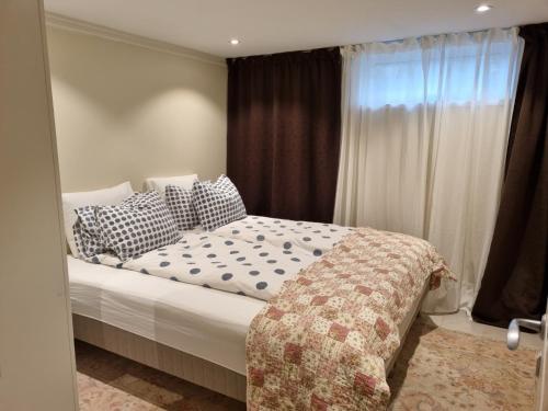 een slaapkamer met een bed met kussens en een raam bij 90 m2 charmig källarlägenhet nära natur och stad in Mölndal