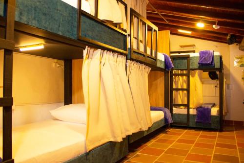 a room with two bunk beds with curtains at Hostal Colombian Gold in San Gil
