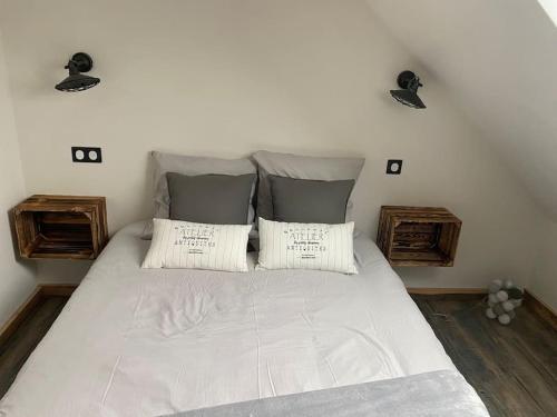 ein Schlafzimmer mit einem großen Bett mit zwei Kissen in der Unterkunft Als AS DE COEUR La maison aux mille et un coeurs in Neuve-Église