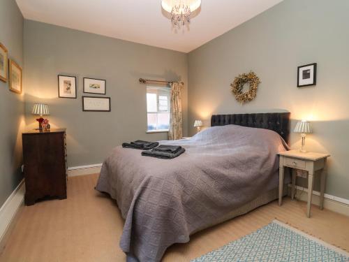 a bedroom with a bed and a table and a window at 11a Market Cross Place in Aldeburgh