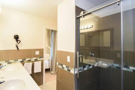 a bathroom with a sink and a glass shower at The Venice Oasis - 4BR-3BA 16 Guests in Atlantic City