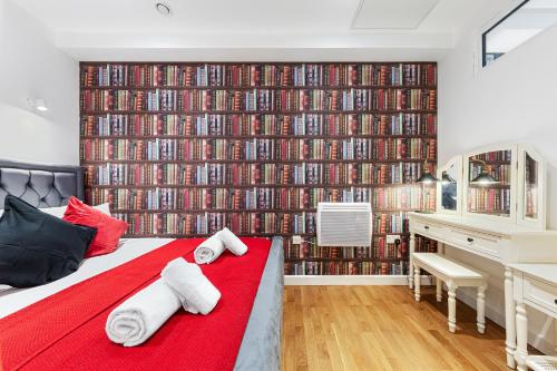 a bedroom with a large wall of dvds at Stylish One Bedroom Flat - Sleeps 3 - Near Heathrow, Windsor Castle, Thorpe Park - Staines London TW18 in Staines upon Thames