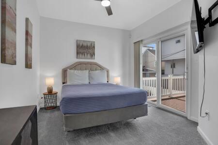um quarto com uma cama e uma varanda em Bartram Dream House I - Bartram Beach Retreat em Atlantic City