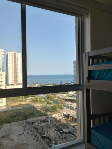 a view of the ocean from a bedroom window at Salguero suites resort in Gaira