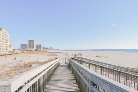 a wooden boardwalk leading to a beach with buildings at Bartram Dream House II - Bartram Beach Retreat in Atlantic City