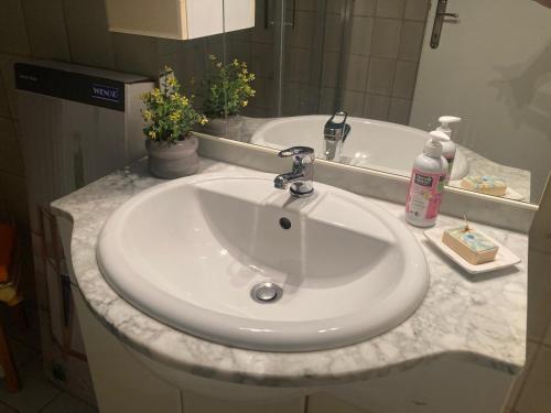 lavabo blanco en el baño con espejo en VILLA BRUNEGG Leoben GÖSS, en Leoben