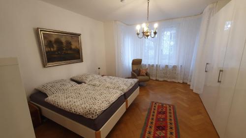 a bedroom with two beds and a chandelier at Stadtvillenwohnung nahe Zentrum / Ruhrfestspielhaus in Recklinghausen
