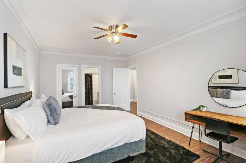 a bedroom with a bed with a ceiling fan and a desk at Cozy & Radiant 2BR Apartment - BStone 605 in Chicago