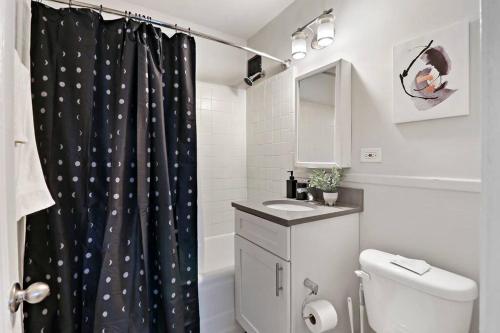 a bathroom with a toilet and a shower curtain at Cozy & Radiant 2BR Apartment - BStone 605 in Chicago