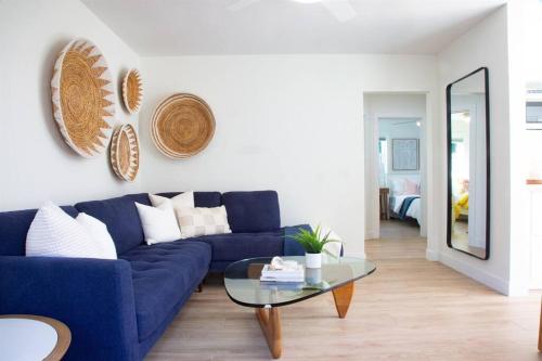 uma sala de estar com um sofá azul e uma mesa de vidro em Adorable Octopus Hideaway: 2 min walk to the beach em Del Mar