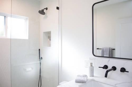 a bathroom with a shower and a sink and a mirror at Adorable Octopus Hideaway: 2 min walk to the beach in Del Mar