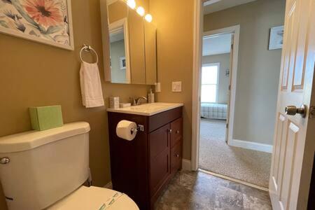 ein Badezimmer mit einem WC, einem Waschbecken und einem Spiegel in der Unterkunft Beach Vacation Home - Quiet Neighborhood in AC! in Atlantic City