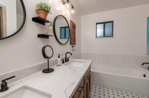 ein Badezimmer mit zwei Waschbecken, einer Badewanne und einem Spiegel in der Unterkunft Coyote Den in Arnold