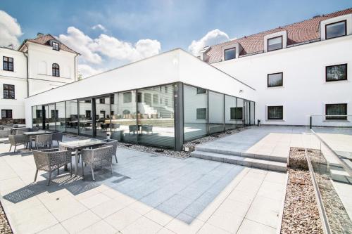 a large white building with glass doors and a patio at Hanza Pałac Wellness & SPA in Warlubie