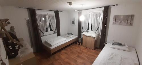 a room with two beds and two windows at Haus Nevita in Saas-Grund