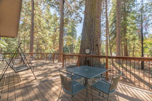 a wooden deck with a table and chairs next to a tree at Peaceful Pinecone in Dorrington