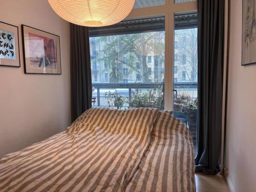 1 dormitorio con cama y ventana grande en Central family home in award-winning architecture en Copenhague
