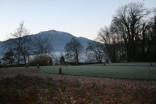 a mountain in the distance with a field and trees at Villa San Liberale - Suites & Wellness - Villa Veneta in Feltre
