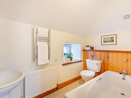 a bathroom with a toilet and a sink and a tub at 2 Bed in Coldingham 93242 in Duns