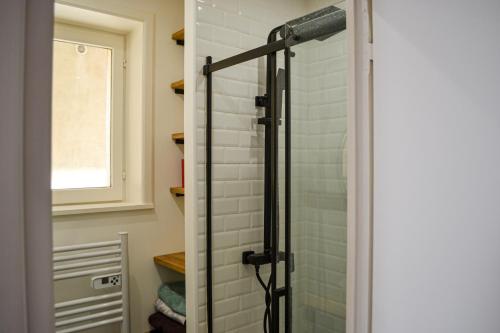 une douche avec une porte vitrée dans une salle de bain dans l'établissement Résidence Caladoise - Rue Centrale, à Villefranche-sur-Saône